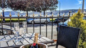 A table with a champagne bottle, glasses, and a chair. - The Wildings (Llandudno)