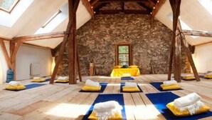 A spacious room with wooden floors, stone walls, and a sloped ceiling with skylights. - Alpenretreat (Nassereith)