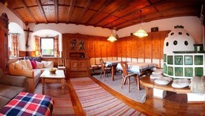 A cozy living room with a sofa, a coffee table, and a dining area with a table and chairs. - Alpenretreat (Nassereith)
