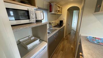 Een koelkast, een oven, een kookplaat, een koffiezetapparaat/waterkoker