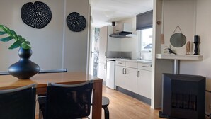 A modern kitchen with white cabinets, a black stove, and a black fireplace. - CS 48 - Callassande Vacation Park (Callantsoog)