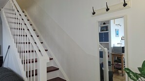 A staircase with white railings and wooden steps leading to a room with a desk, shelves, and a plant. - Duplex with 3 rooms in a quiet neighbourhood (Var)