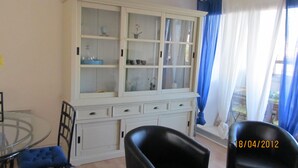 A room with a white cabinet with glass doors, a glass table, and two black chairs. - Duplex with 3 rooms in a quiet neighbourhood (Var)
