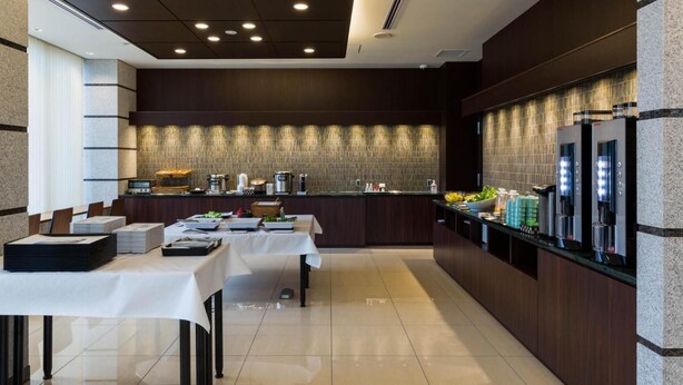 A modern hotel room with a dining area, a kitchen counter, and a refrigerator. - N Gate Hotel Osaka (Tajiri)