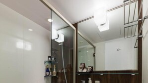 A modern bathroom with a glass-enclosed shower, a white sink, and a toilet. - N Gate Hotel Osaka (Tajiri)