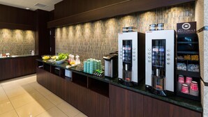 A hotel reception area with a counter, a beverage dispenser, and a small salad display. - N Gate Hotel Osaka (Tajiri)
