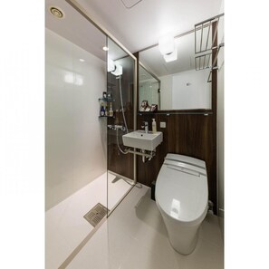A modern bathroom with a glass-enclosed shower, a white sink, and a toilet. - N Gate Hotel Osaka (Tajiri)