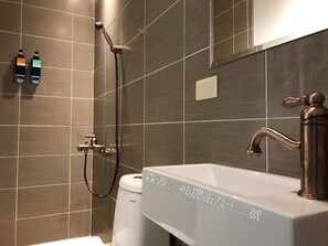 A modern bathroom with a large sink, a handheld showerhead, and two soap dispensers. - Sennong Homestay (Tainan)