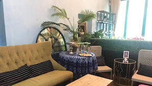 Un salon confortable avec un canapé, une table en bois et une petite table ronde sur laquelle figure un code QR.
