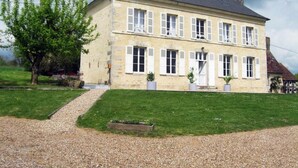 A two-story stone building with a symmetrical facade, multiple windows with shutters, and a central entrance. - Spacious House with Indoor Pool and Wifi in Laleu (Laleu)