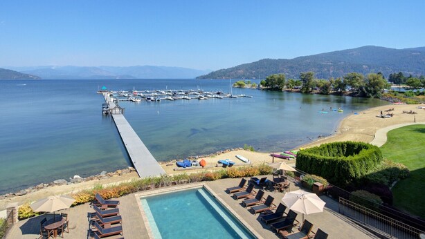 A resort with a swimming pool, lounge chairs, and a view of the lake and dock. - A Scenic Canvas, Lakefront - Seasons at Sandpoint (Sandpoint)