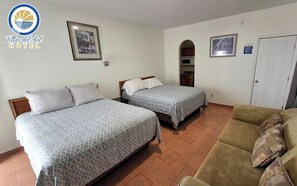 A hotel room with two beds, a sofa, a microwave, and a door.