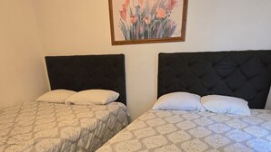Two twin beds with patterned bedding in a room with tiled flooring. - Hotel Villas Del Sol (Golfo de Santa Clara)