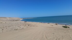 A beach with a sandy landscape and a clear blue sky.