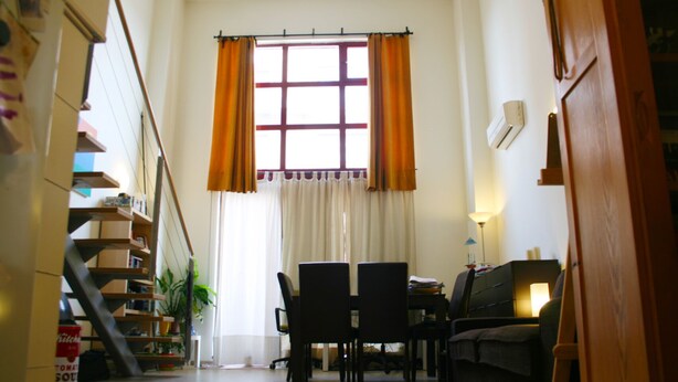 A compact living space with a dining area, a sofa, a lamp, and a staircase leading to a loft. - IMPRESSIVE LOFT, MADRID, NEXT TO THE METROPOLITAN WANDA (Madrid)