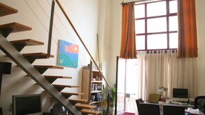 A spacious room with a staircase, a desk with a computer, and a bookshelf. - IMPRESSIVE LOFT, MADRID, NEXT TO THE METROPOLITAN WANDA (Madrid)