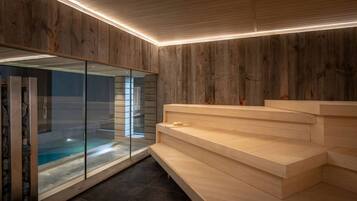Un interior moderno con pared de madera, un recinto de vidrio con piscina y una escalera de madera.