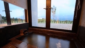 A hot tub with a view of a landscape through large windows. - Minamiaso Kugino Onsen Ryokan Konomama (Minamiaso)