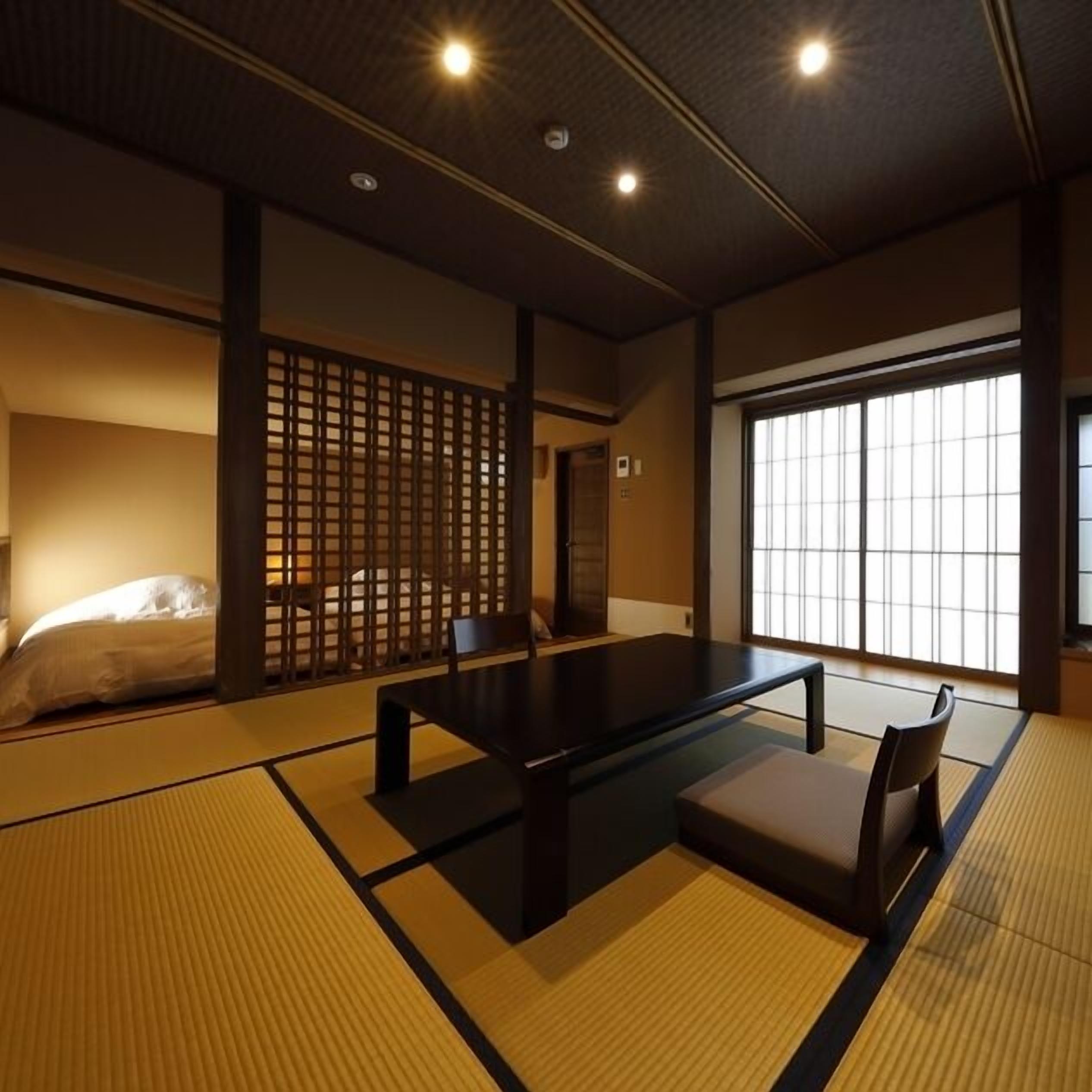 A traditional Japanese room with tatami flooring, a low table, and a sliding door.