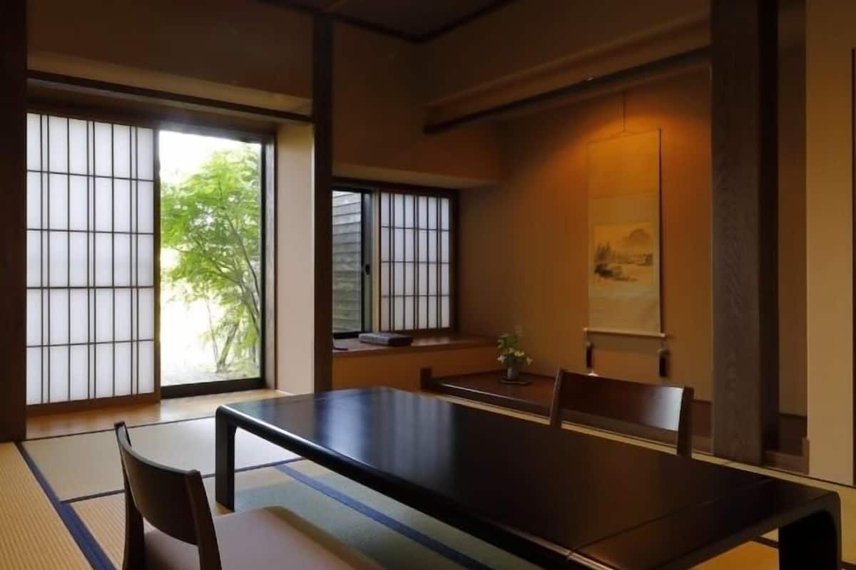 Ein traditioneller japanischer Raum mit Tatami-Boden, einem niedrigen Tisch und Schiebetüren.