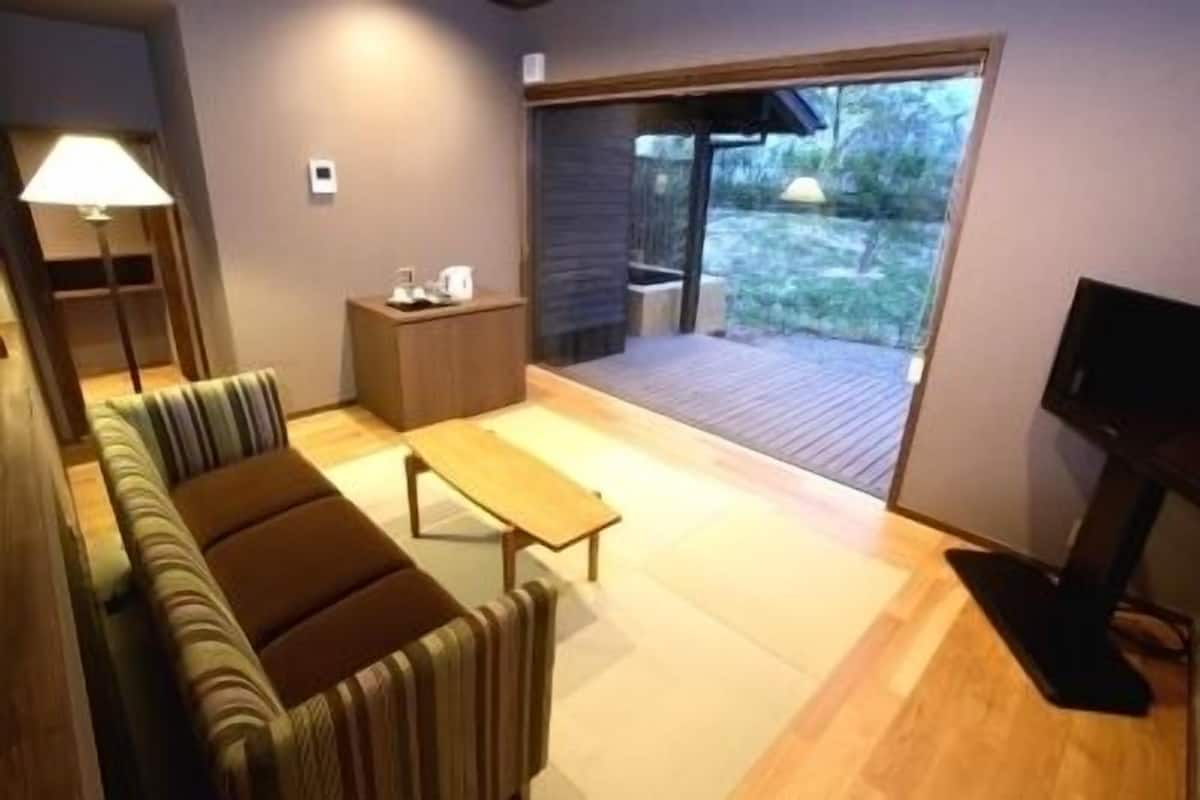 Ein modernes Wohnzimmer mit einer Couch, einem kleinen Tisch und einem Fernseher.