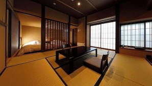 A traditional Japanese room with tatami flooring, a low table, and sliding doors. - Minamiaso Kugino Onsen Ryokan Konomama (Minamiaso)