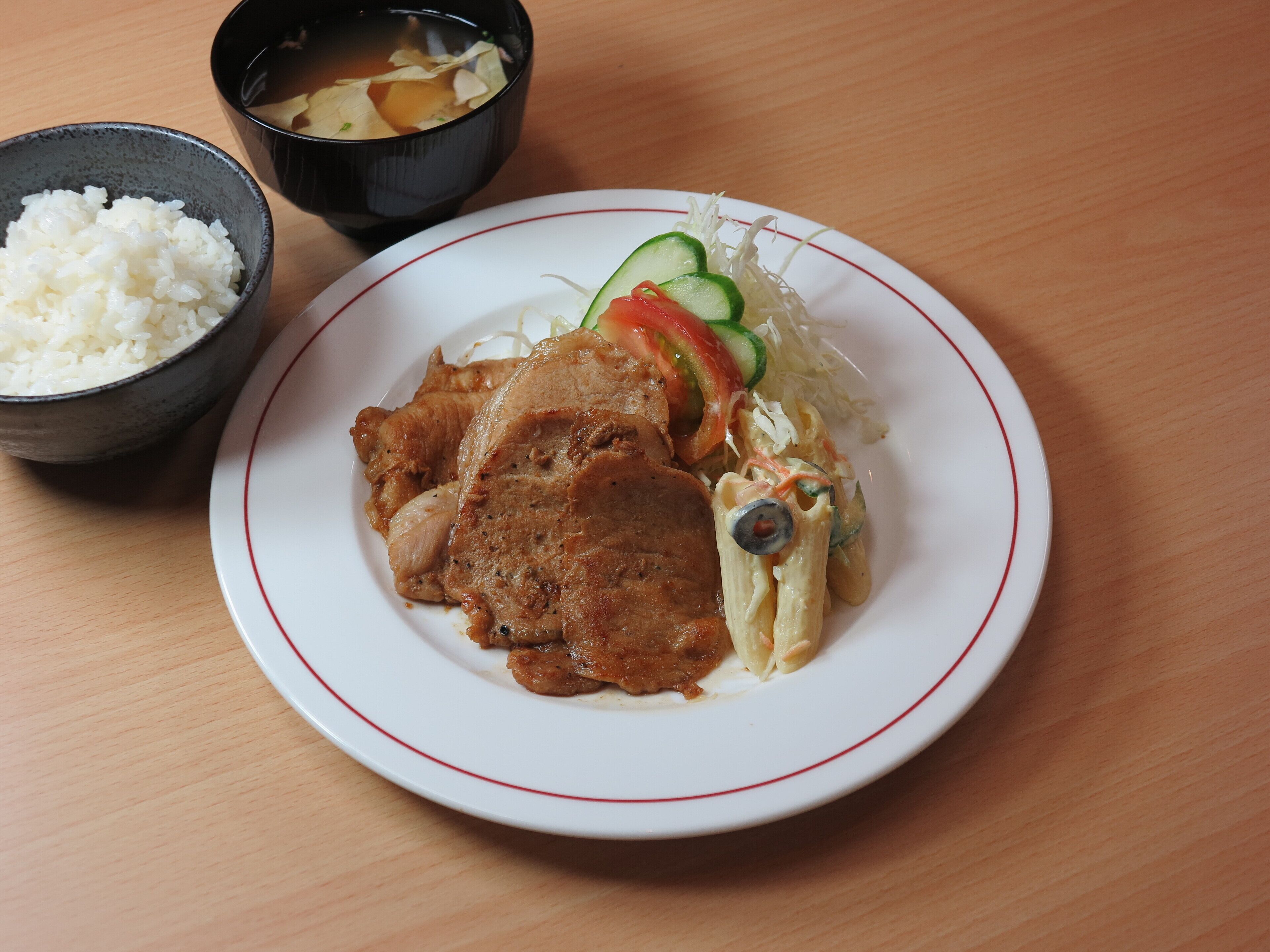 Un plato de comida con arroz, un guiso de carne y verduras.