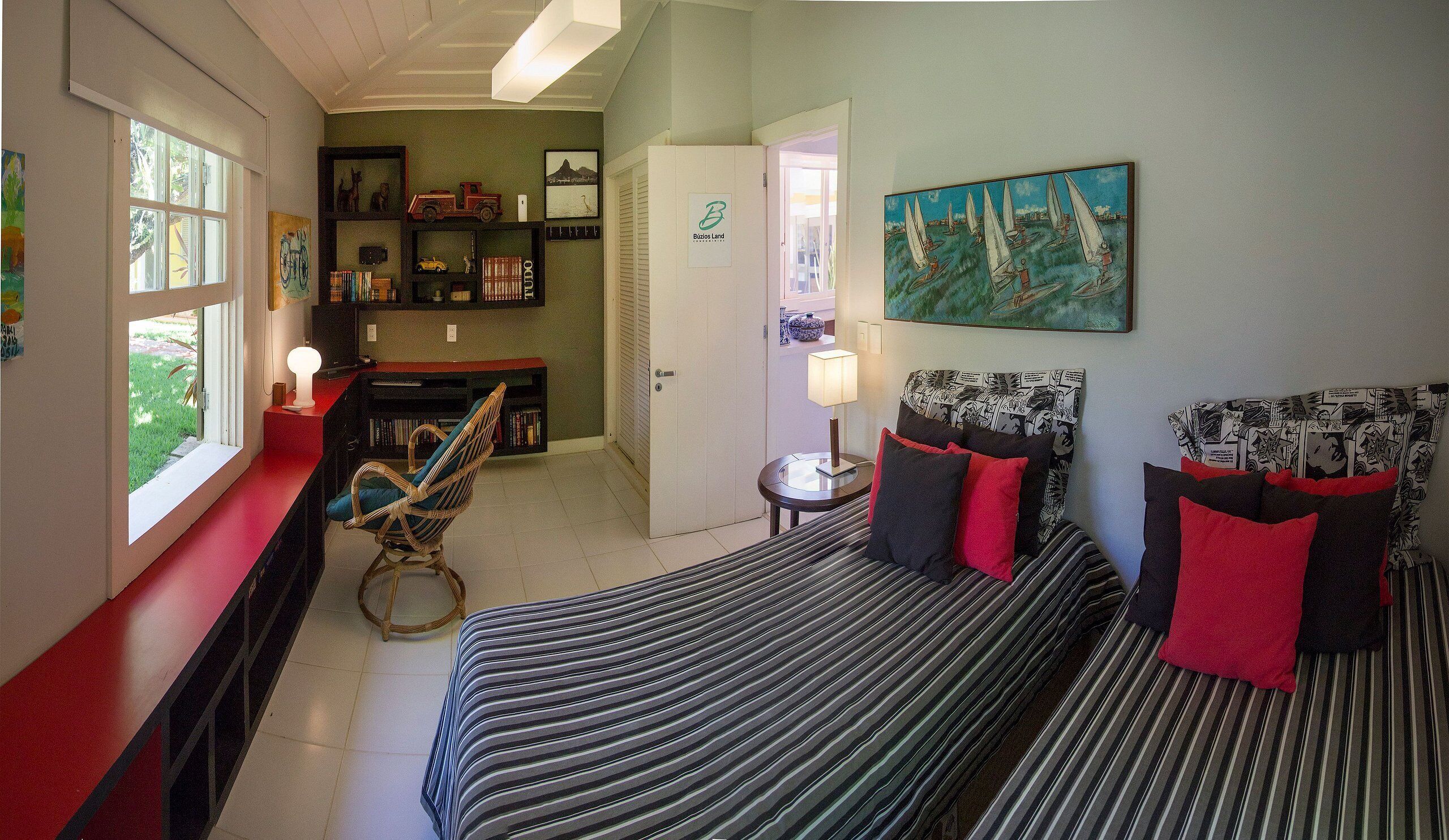 A bedroom with a bed, a chair, a desk, and a bookshelf.