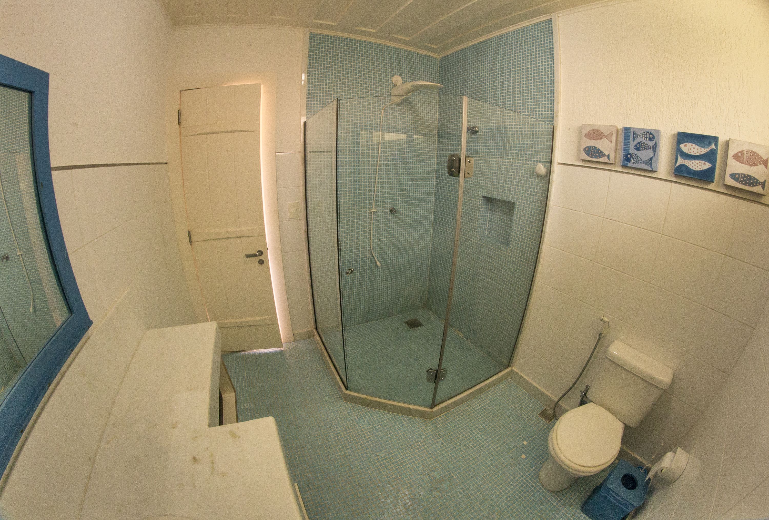 Un baño con cabina de ducha de vidrio, inodoro y lavabo.