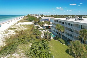Un hôtel situé en bord de mer, doté de nombreux balcons, d’une piscine et offrant une vue sur la plage et l’océan.
