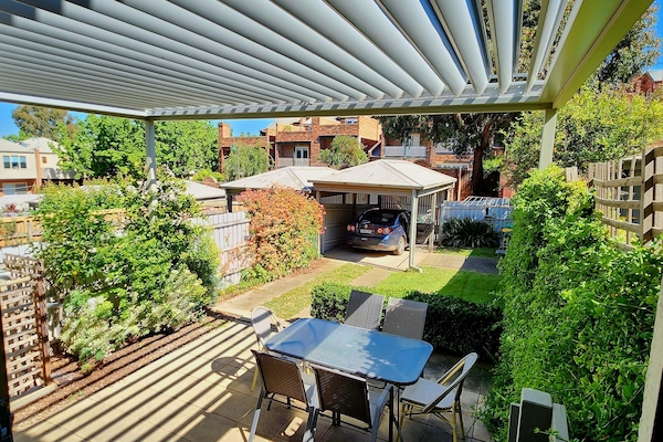 Private rear garden with 2 car spaces, shaded motorised Vergola, BBQ & dining