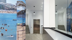 Un intérieur d’hôtel moderne avec vue sur une plage et la mer.