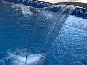 On voit clairement une piscine avec une cascade.