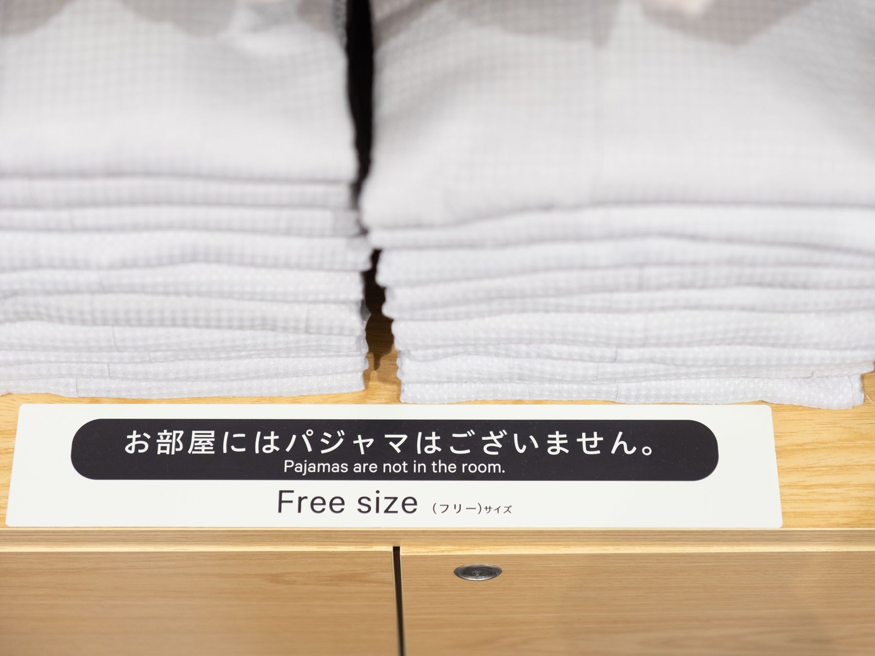 Una cama con un cartel que indica que no se permiten pijamas.
