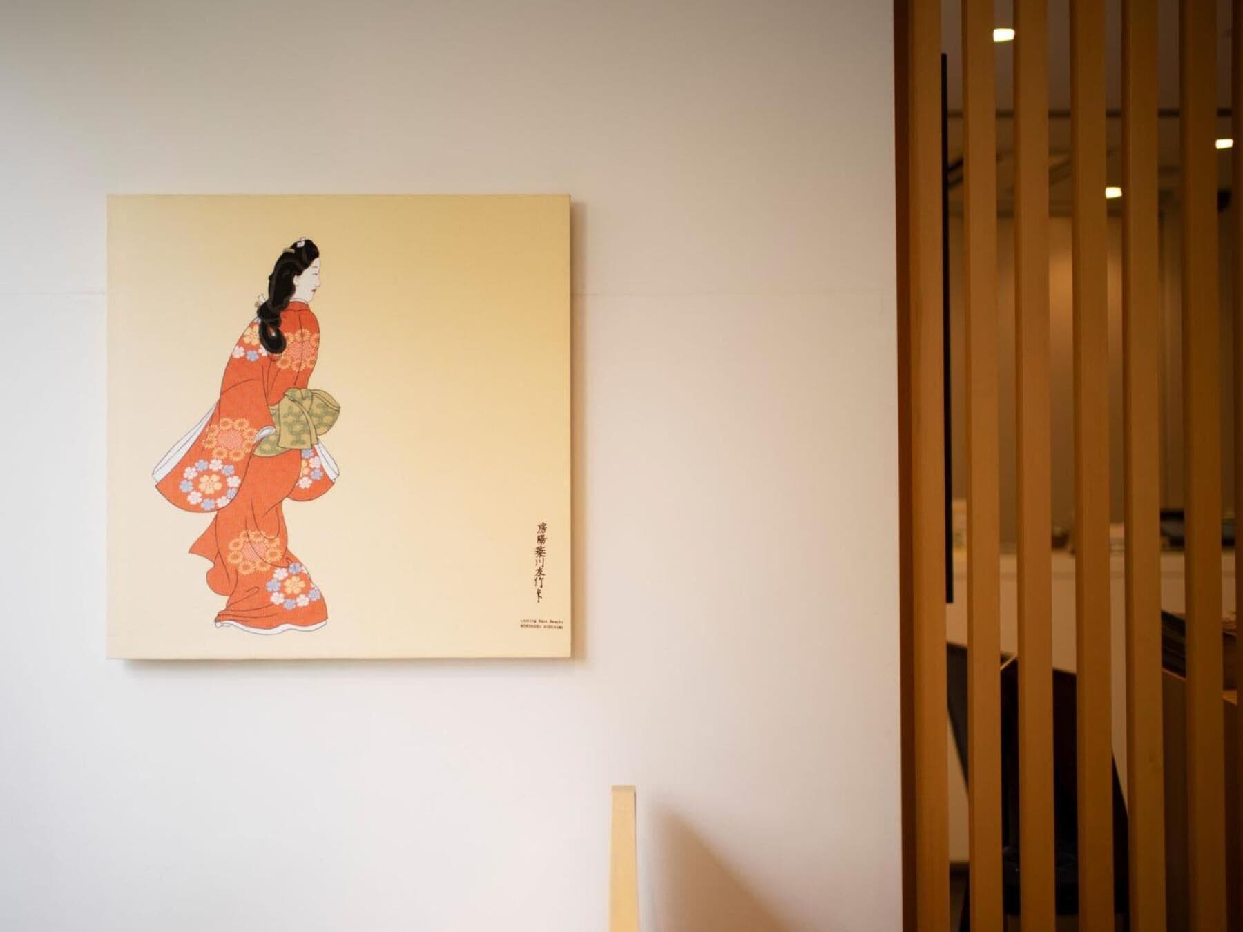 A framed artwork of a figure in traditional attire on a wall.