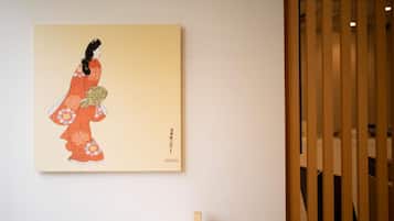 A framed artwork of a figure in traditional attire on a wall.