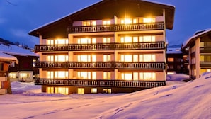 A multi-story hotel with balconies and a snow-covered landscape. - Haus-Alfa (Saas-Fee)