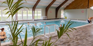 Una piscina cubierta, tumbonas