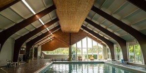 Una piscina cubierta, tumbonas