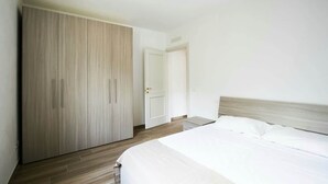 A bedroom with a bed, a wardrobe, and a door. - Apartment "E" Balcony - Levanto Cinque Terre (Levanto)