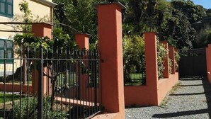 A gated entrance with a gravel path leading to a building with a yellow facade and green shutters. - Apartment "E" Balcony - Levanto Cinque Terre (Levanto)
