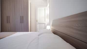 Ein Schlafzimmer mit einem Bett, einem Kleiderschrank und einer Tür zu einem anderen Raum.