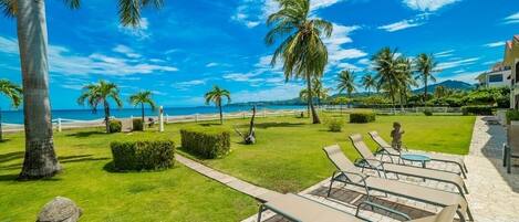 Un resort con piscina, sillas de descanso y palmeras.