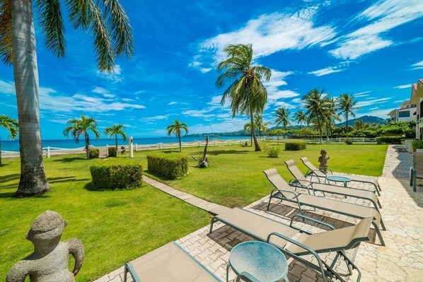 A resort with a pool area, lounge chairs, and palm trees.