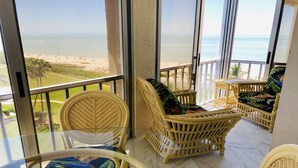 A balcony with wicker furniture overlooking a beach. - SHELLebrations: Gulf-Front Penthouse Paradise on Fort Myers Beach, Florida (Fort Myers Beach)