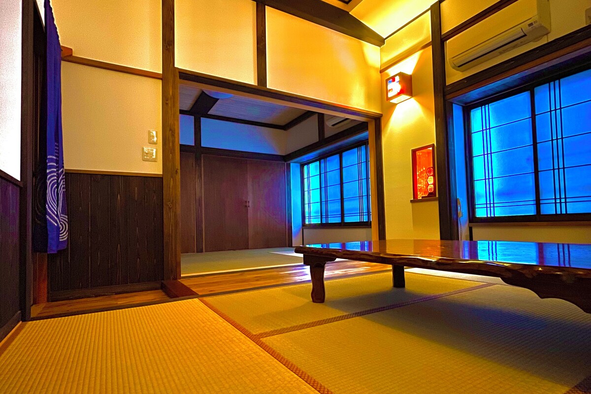 Ein traditioneller japanischer Raum mit Tatami-Bodenbelag, Schiebetüren und einer hölzernen Sitzbank.