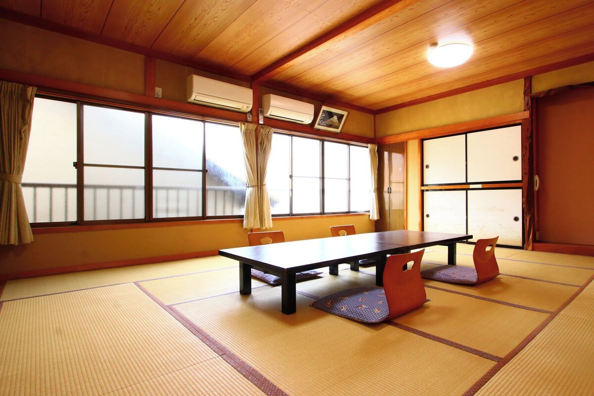 Ein traditioneller japanischer Raum mit Tatami-Böden, einem niedrigen Tisch und Schiebetüren.