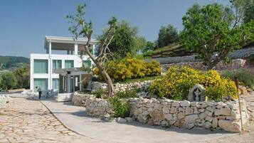Un edificio moderno a due piani con un vialetto in pietra che conduce a una zona relax.