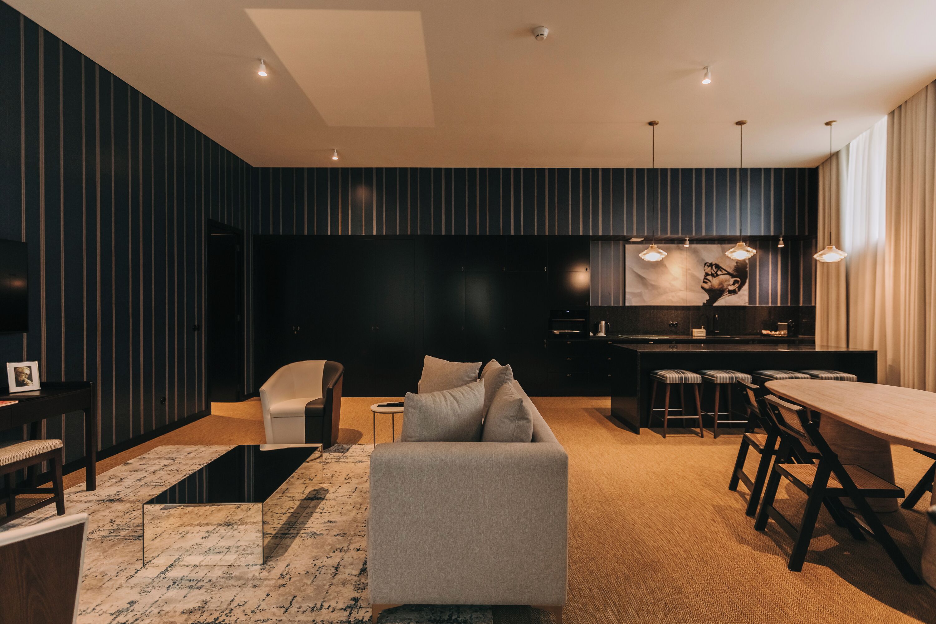 Un salon moderne comprenant un canapé, une table basse et un coin repas avec une table et des chaises.