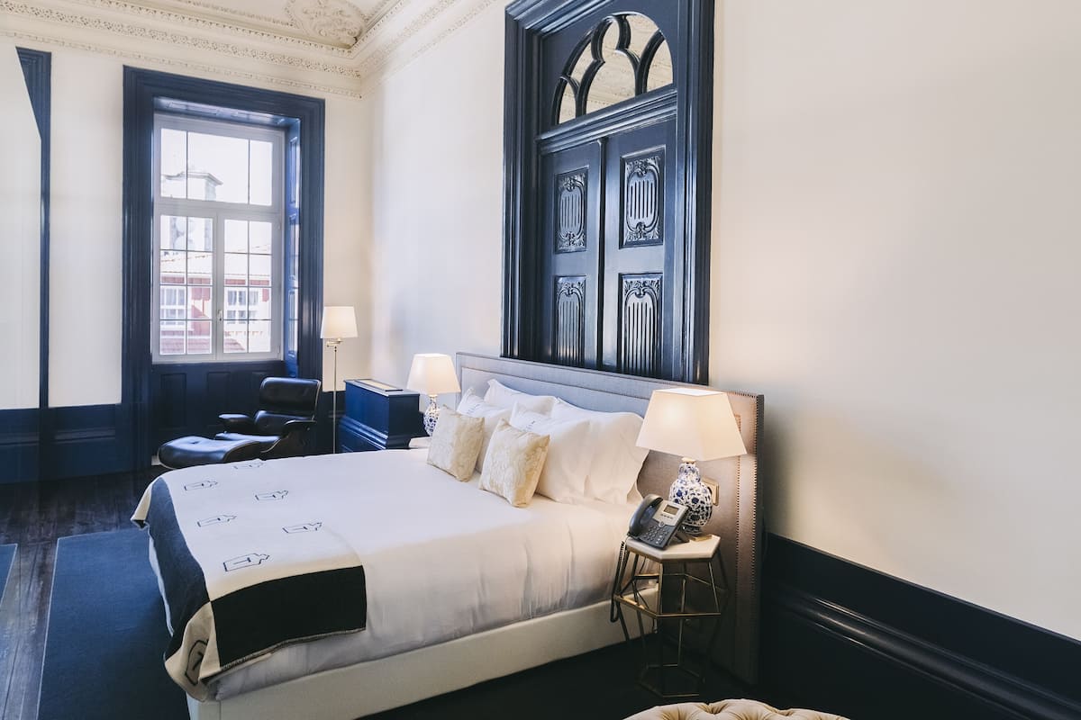 Une chambre d’hôtel avec un grand lit, une table de chevet, une lampe et un plafond décoratif.